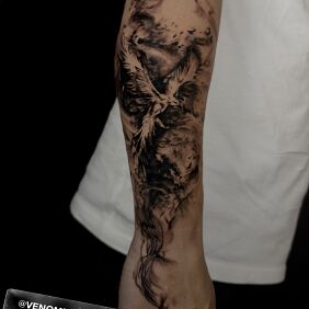 Tattoo Feniks w smugach dymu on the forearm motif: black and gray style: graphic / illustrative