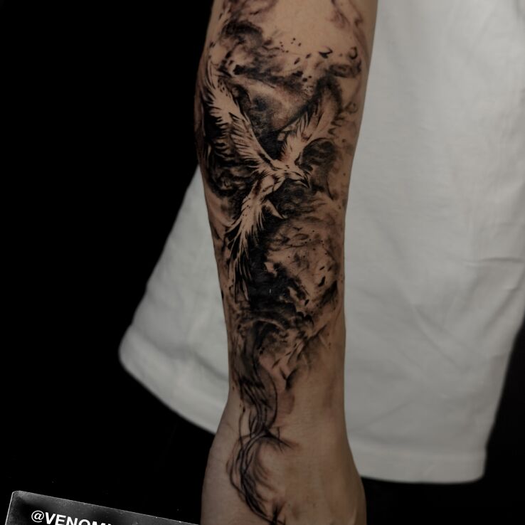 Tattoo Feniks w smugach dymu in black and gray motif and graphic / illustrative style On the arm