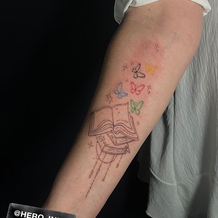 Tattoo Książka z motylkami in butterflies motif and contour / linework style on the forearm