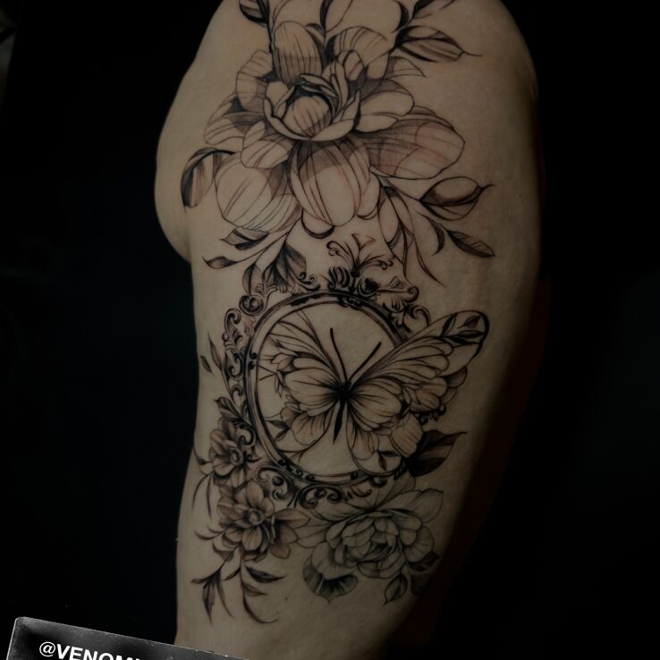 Tattoo Kwiaty i motyl in black and gray motif and graphic / illustrative style on the thigh