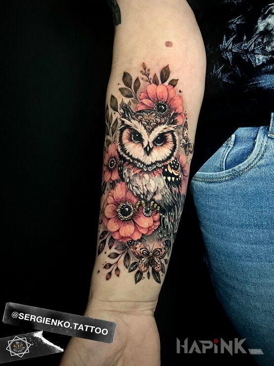 Tattoo Owl with flowers in colorful motif and realistic style On the arm