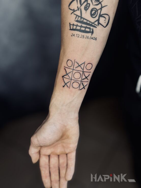 Tattoo Kółko i krzyżyk in black and gray motif and ignorant style on the forearm