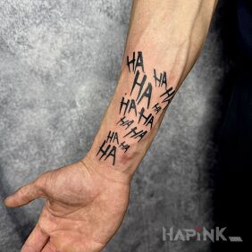 Tattoo Ha ha ha on the forearm motif: black and gray style: blackwork / blackout