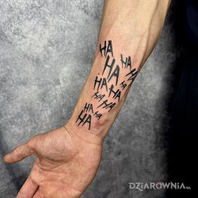 Tatuaż Ha ha ha na przedramieniu motyw: czarno-szare styl: blackwork / blackout