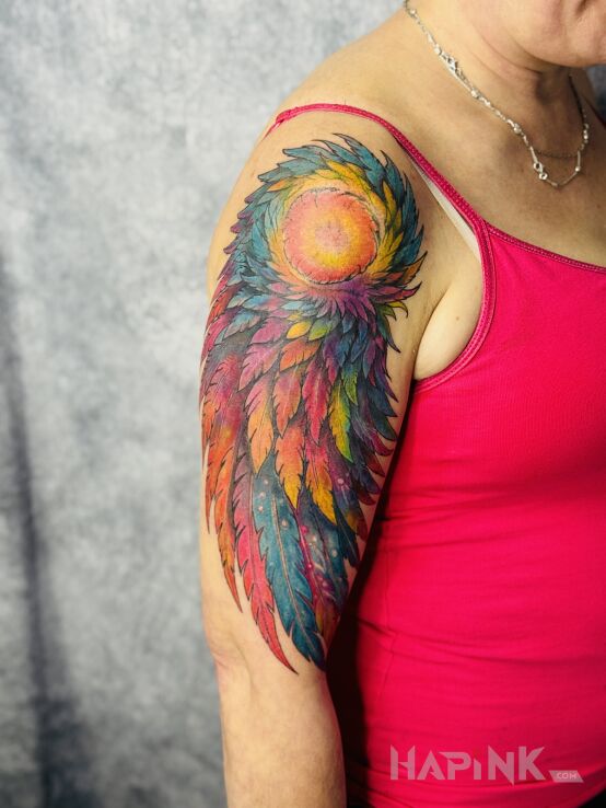 Tattoo Kolorowe pióra in cover-up motif and graphic / illustrative style on the upper arm