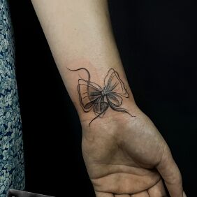 Tattoo Kokardka On the arm motif: objects style: graphic / illustrative