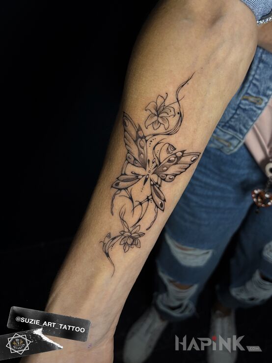 Tattoo Butterfly in flowers motif and graphic / illustrative style On the arm