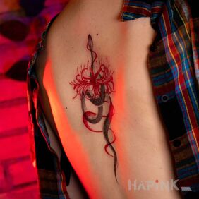 Tattoo Delicate graphic snake with spider lilies on the back on the back motif: floral style: graphic / illustrative