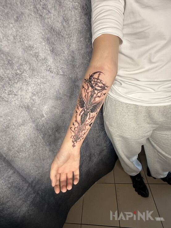 Tattoo Cross with an Angel in angels motif and Celtic / Nordic style On the arm