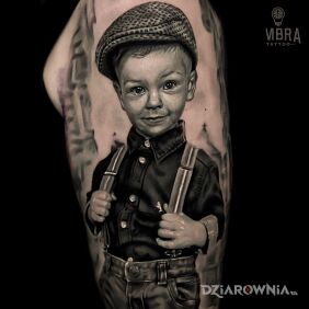 Tatuaż Portret chłopca w kaszkiecie i szelkach — realizm black & grey na ramieniu motyw: postacie styl: realistyczne