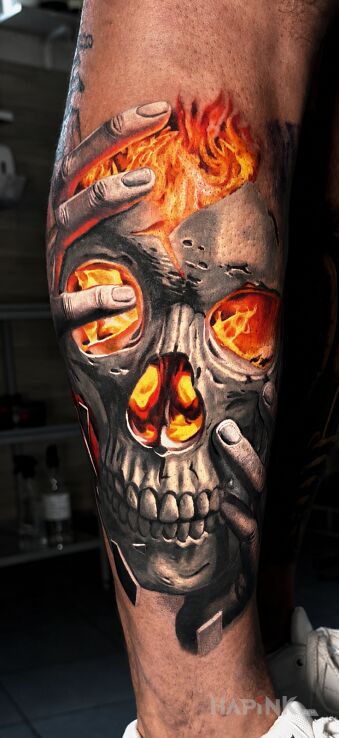 Tattoo Płonąca czaszka w dłoniach in colorful motif and realistic style on the leg