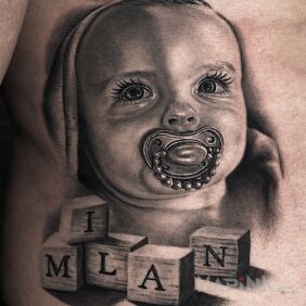 Tattoo Portrait of an infant with a pacifier and blocks with a name — black & grey on the ribs motif: characters style: realistic