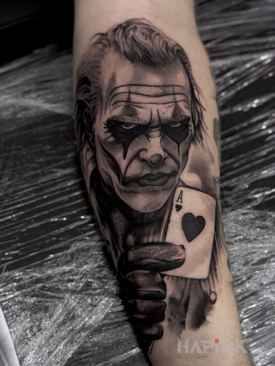 Tattoo Joker with Ace of Hearts – Black & Grey in dark motif and realistic style On the arm