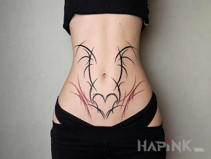 Tattoo Cierniowe serce na brzuchu in ornaments motif and blackwork / blackout style on the stomach