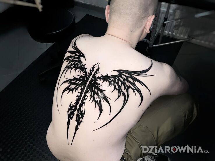 Tatuaż Skrzydlaty miecz w motywie czarno-szare i stylu blackwork / blackout na łopatkach