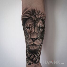 Tattoo Lion and leaves — black & grey on the forearm motif: black and gray style: realistic