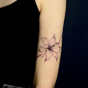 Tattoo Lilia on the upper arm style: graphic / illustrative