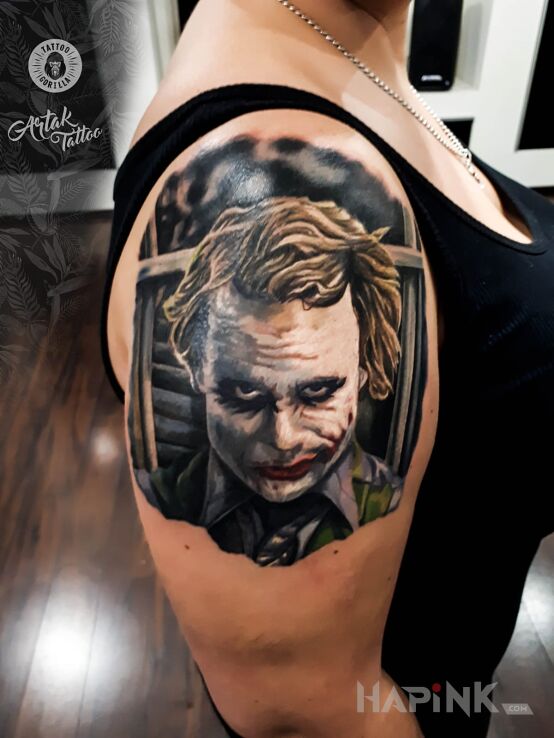 Tattoo Joker in characters motif and realistic style on the upper arm