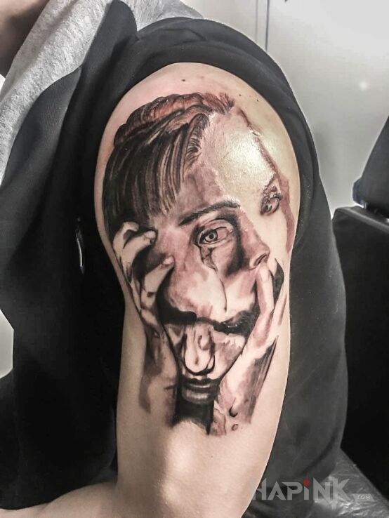 Tattoo 2 faces in faces motif on the upper arm