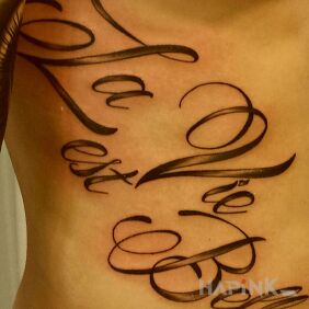 Tattoo La Vie est Belle on the ribs motif: lettering