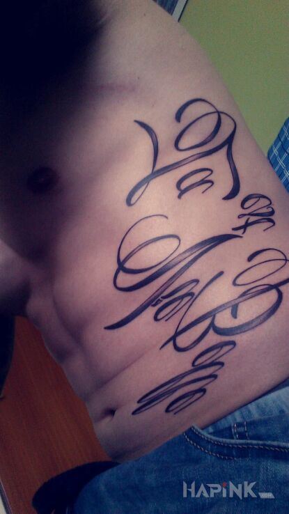 Tattoo La Vie est Belle in lettering motif on the ribs