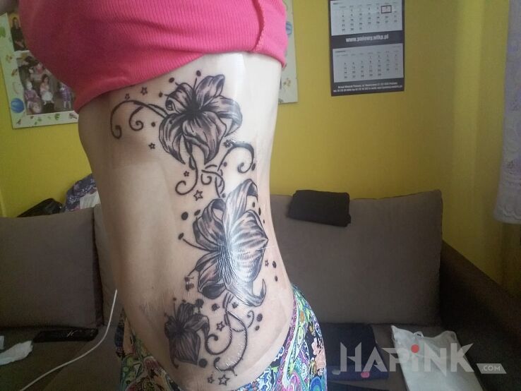 Tattoo Kwiatki in flowers motif on the ribs