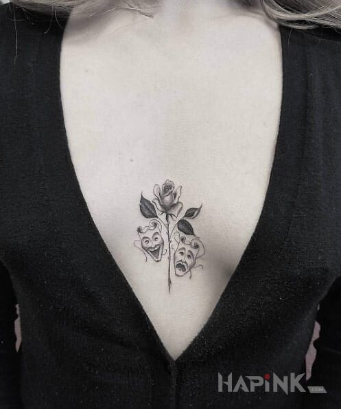 Tattoo Teatralne maski in black and gray motif and graphic / illustrative style between the breasts