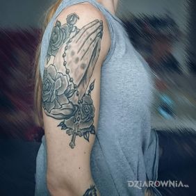 Tatuaż Dłonie z różańcem na ramieniu motyw: religijne
