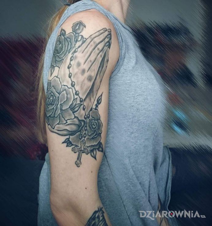 Tatuaż dłonie z różańcem w motywie religijne na ramieniu