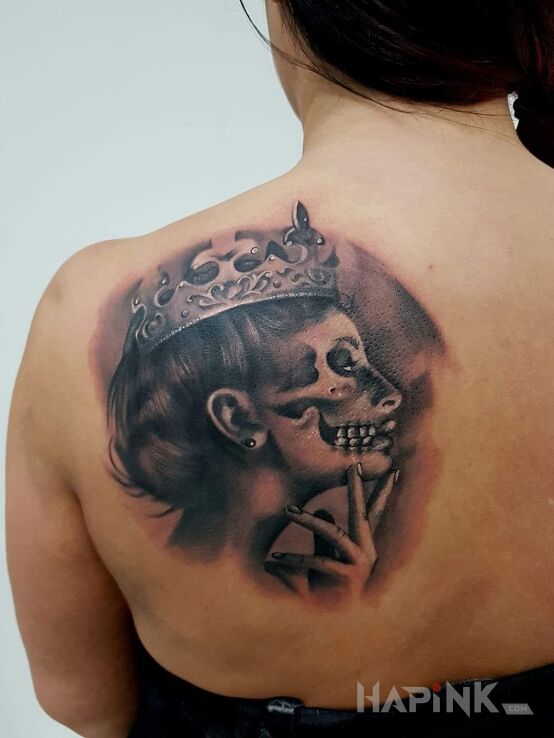 Tattoo Królowa in faces motif on the shoulder blades