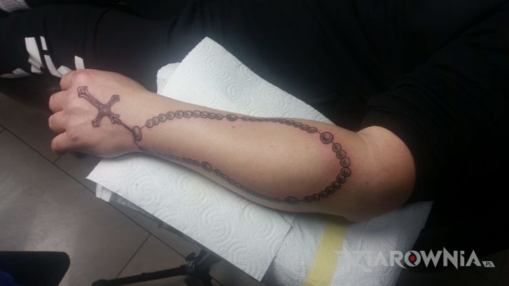 Tatuaż rozaniec w motywie religijne na przedramieniu