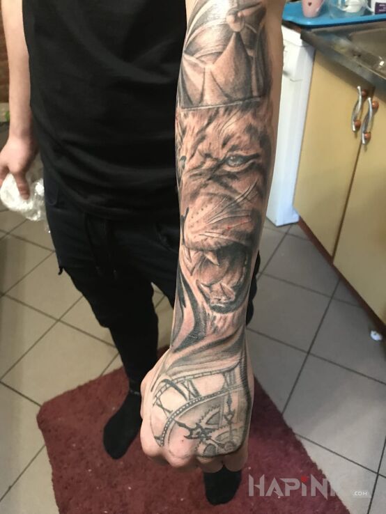 Tattoo Lew in animals motif and realistic style on the hand