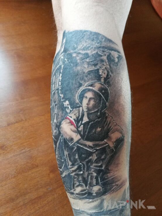Tattoo Mały powstaniec na gruzach Warszawy in patriotic motif on the forearm