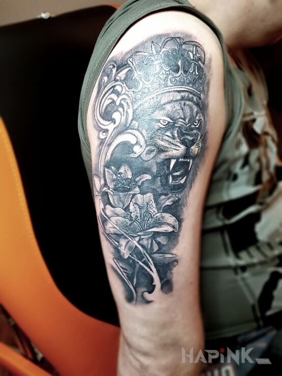 Tattoo Lew in animals motif on the upper arm