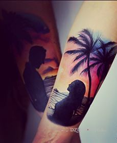 Tatuaż para pod palmami w motywie kolorowe na przedramieniu