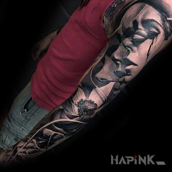 Tattoo Zmieniajaca sie twarz in flowers motif and realistic style on the upper arm
