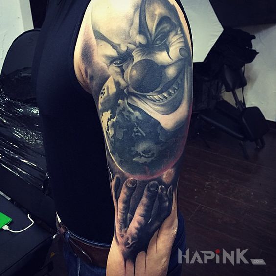 Tattoo Demoniczny clown in faces motif and realistic style on the upper arm