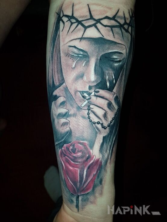 Tattoo Zakonnica w łzach in flowers motif on the forearm
