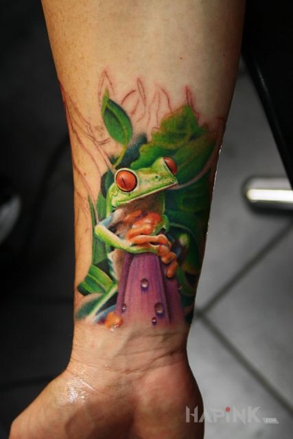 Tattoo Zielona zabka in colorful motif and realistic style on the forearm