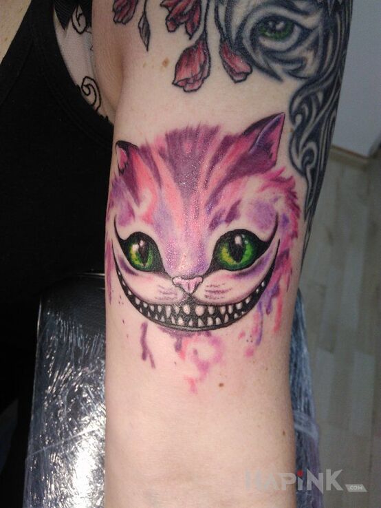 Tattoo Kot z Cheshire in colorful motif on the upper arm