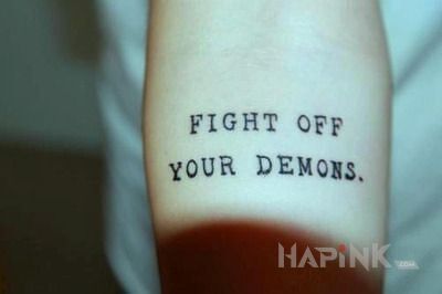 Tattoo Walka z demonami in lettering motif on the forearm