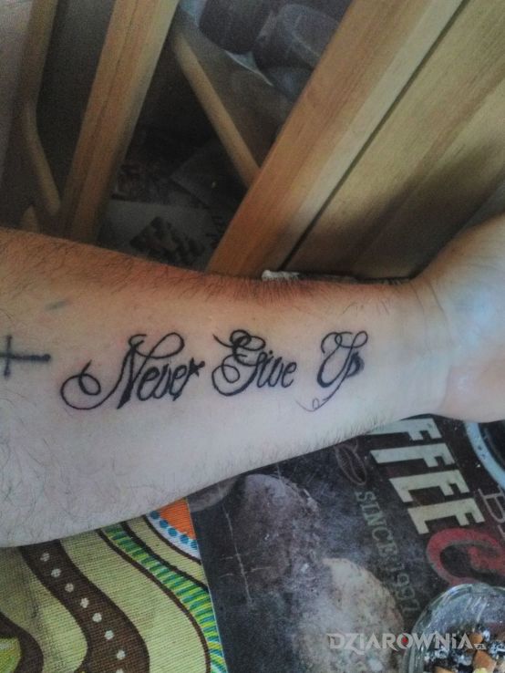 Tatuaż never give up w motywie napisy na przedramieniu
