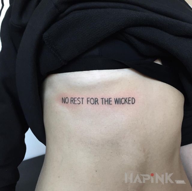 Tattoo Brak odpoczynku in lettering motif on the ribs