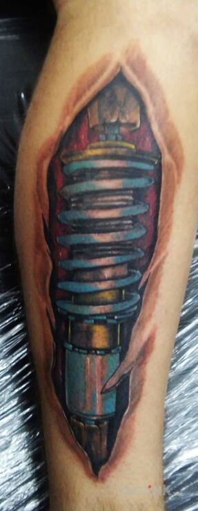 Tattoo Amorek in biomechanics style on the calf