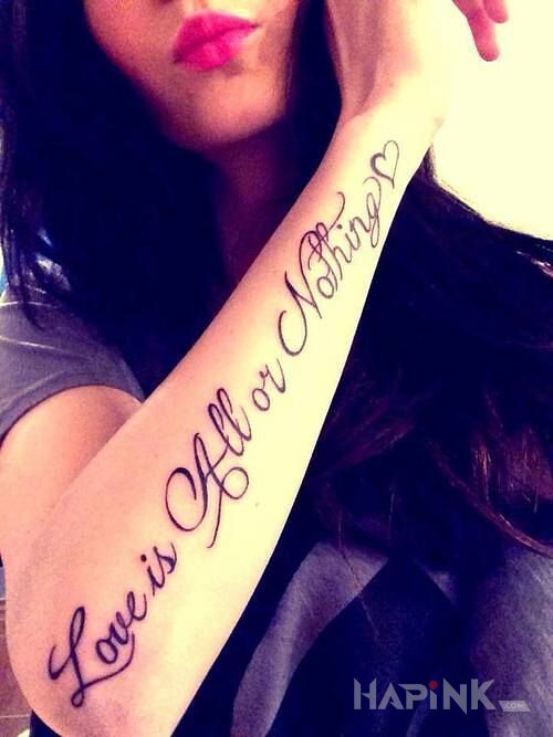 Tattoo Milosc albo nic in lettering motif on the forearm