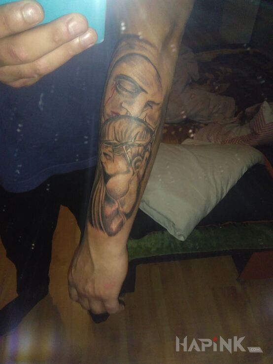 Tattoo Matka boska in faces motif on the forearm