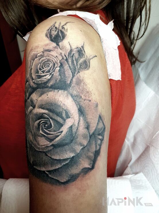 Tattoo Roza in flowers motif on the upper arm