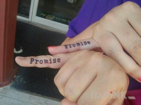 Tattoo Obietnica in lettering motif on the fingers