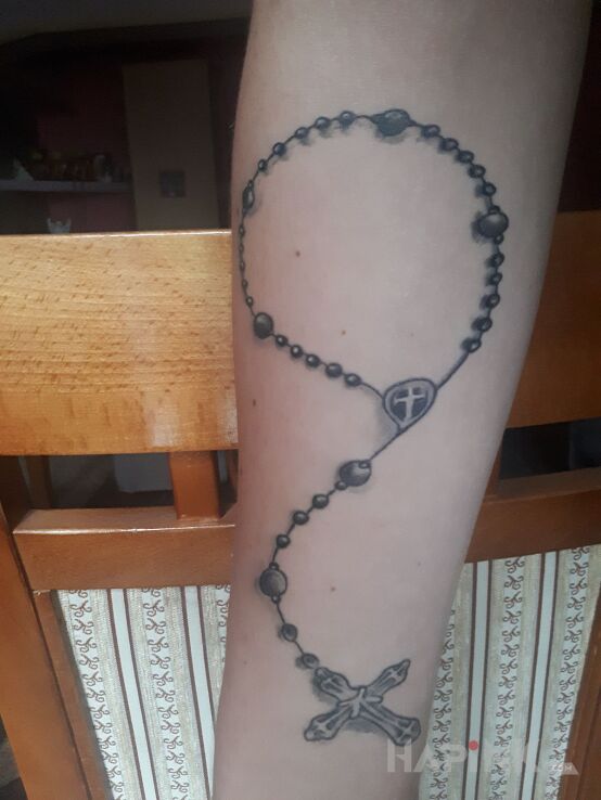 Tattoo Różaniec in religious motif on the forearm