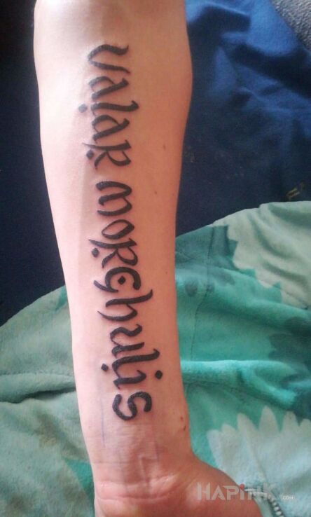 Tattoo Każdy musi umrzeć in lettering motif on the forearm